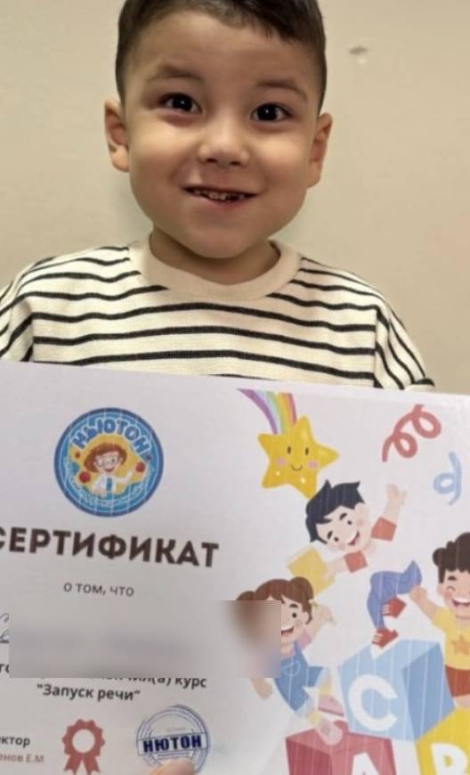 Мальчик держит именной сертификат об окончании курса «Запуск речи»